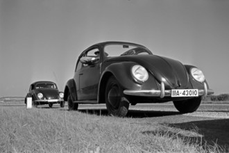 KdF Wagen Zwei Modelle des Volkswagen Käfer, oder KdF Wagen, mit offenem und geschlossenem Dach am Rande einer Teststrec