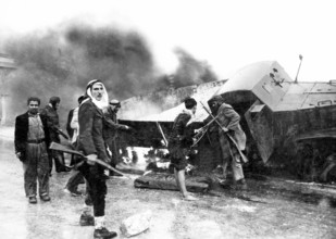 Israel / Palestine: Palestinian fighters beside a burned-out Israeli Haganah supply truck near Jerusalem, Arab-Israeli W