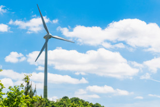 Munich, Bavaria, Germany - 30 May 2025: A large SWM wind turbine is located on the Fröttmaninger Müllberg, generating gr