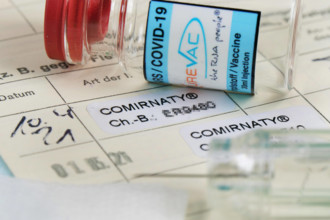 2ter Covid-19 Eintrag in einem Impfpass bei medizienischem Personal mit Serumflasche. Impfung-Covid-19 *** 2nd Covid 19