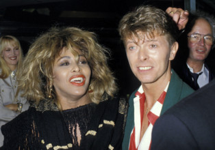 TINA TURNER & DAVID BOWIE London, England, Circa 1985 headshot portrait red lips lipstick red white stripe shirt green j
