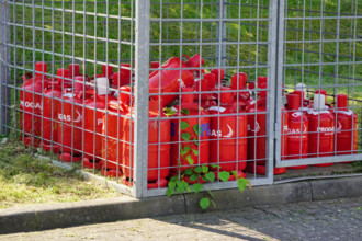 Flüssiggas, rote Gasflaschen der Firma PROGAS hinter einem Sicherheitsgitter *** Liquid gas, red Gas cylinders the Compa