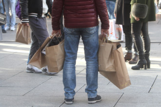 Ein Mann trägt viele Papiertüten in der Fußgängerzone und Einkaufsstraße Zeil in der Innenstadt von Frankfurt, Hessen,