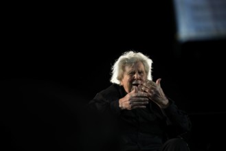 Mikis Theodorakis, 95. Geburtstag am 29. Juli Mikis Theodorakis conducting as seen from between the feet of the first ro