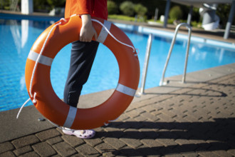 Bademeisterin mit Rettungsring im Schwimmbad. Bonn Deutschland *** Lifeguard with life belt in swimming pool Bonn Germa