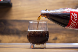 Cola trinken Eine Frau schüttet in ein Glas Cola von Coca Cola ein. Foto: Kirchner-Media/Symbolkraft Deutschland *** Dri