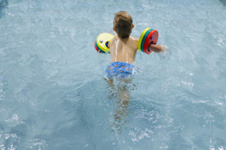Thema: Vorschulkind beim Schwimmunterricht mit Schwimmfluegeln in einem oeffentlichen Bad. Bornheim Deutschland *** subj
