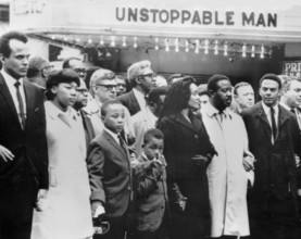A cinema bill provides an ironic background during the march for slain civil rights leader Dr Martin