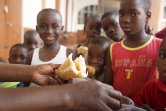 Frau versorgt Kinder mit einer Mahlzeit, Cotonou, Benin, 03.01.2016. . Cotonou Benin PUBLICATIONxINxGERxSUIxAUTxONLY Co