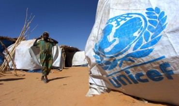Kleines Mädchen neben einem Zelt der UNICEF in einem Flüchtlingslager der Vereinten Nationen nahe Mallit in der Provinz