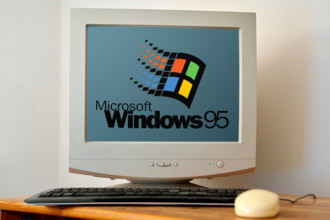 April 21, 2024: Old computer on a desk with a screen showing the Microsoft Windows 95 logo. PHOTOMONTAGE *** Alter Compu