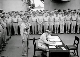 JAPANESE SURRENDER General Douglas MacArthur signs as Supreme Allied Commander during formal surrender ceremonies on the