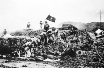 RECORD DATE NOT STATED Vietnam: Victorious Viet Minh troops wave a Vietnamese flag over captured French command post at