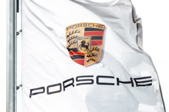 Das Logo von Porsche ist auf einer Flagge vor dem Porsche Zentrum Schwarzwald-Baar zu sehen, die im Wind weht. Villingen