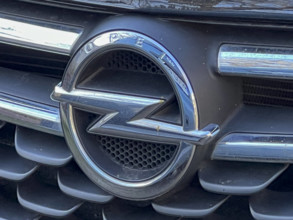 Das Opel Logo Firmenlogo Buchstaben an der Motorhaube eines Opel PKW Die Opel Automobile GmbH ist