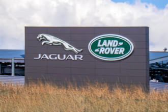 Calgary, Alberta, Kanada. 5. Juni 2025. Die kultigen Logos von Jaguar und Land Rover prangen auf einem modernen Gebäude und stehen für automobile Spitzenleistungen und britisches Erbe.