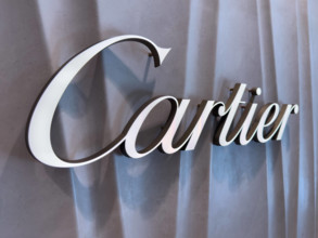Das Logo der Luxusmarke Cartier auf einer strukturierten Wand in einem gehobenen Einzelhandelsgeschäft