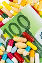 Colourful pills on a 100 Euro bills