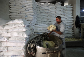 Workers package bread for distribution at the World Food Programme (WFP) bakery after a limited amount of flour entered the Gaza Strip