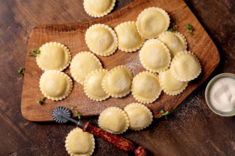 Frische hausgemachte Ravioli auf Holzbrett