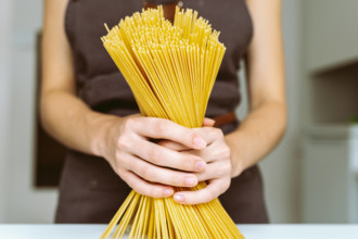 Koch mit Spaghetti in der Hand