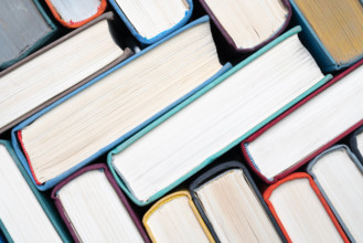 Stack of hardcover books on bookshelf. Close-up view of vintage hardback books as background Stack of hardcover books on