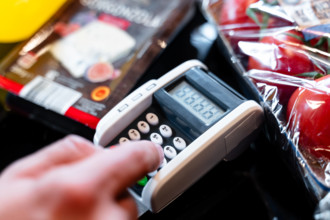 Bavaria, Germany - August 27, 2025: A customer enters their PIN on the card reader at the supermarket checkout. Illustra