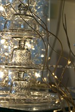 Repas de Noël en strass, idée déco : plateaux et cloches en cristal superposés, et guirlande lumineuse