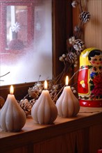Dinner from the Deep North: candles, Russian dolls and tree branches on a window sill