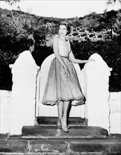Grace Kelly actress at garden gate in her Hollywood home dress sandals