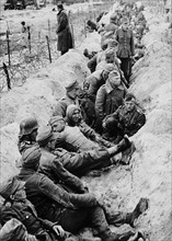 Battle-weary German prisoners are sheltered in one of their own beach defence trenches while