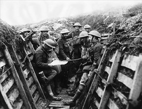 Soldiers from the Kings Liverpool Regiment listening to the news being read out as they wait in