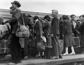 French civilians seen here arriving in a London railway station from Normandy. 
June 1944