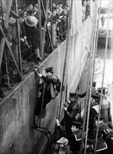 Sailors board HMS Glasow as they prepare for another trip to the beaches of Normandy during WW2