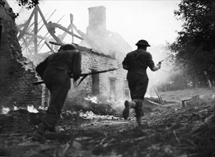 The advance south of Le Beny Bocage continues. British infantry are seen here rushing past the