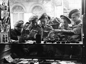 Army Soldiers looking through a shop window - June 1944  for souvenirs to send back home...