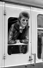 David Bowie leaning out of a railway carriage of the Paris boat train at Victoria station.
Bowie