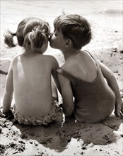 A brotherly kiss on the cheek for his sister while the two children enjoy their summer holiday