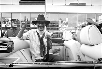 Sammy Davis Jnr in his new Rolls-Royce convertible at Heathrow, where he had his gun and ammunition