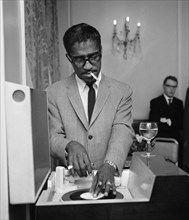 American singer Sammy Davis Jnr. puts on a record in a London restaurant whilst having lunch with