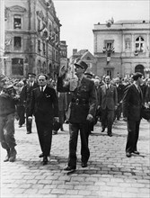 General De Gaulle waves to the wildly cheering crowds
of his countrymen as he leaves the town