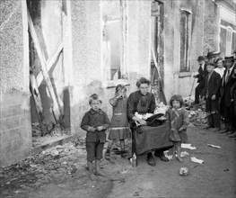 A poor Belgian woman outside her burnt out home in Melle with her four children