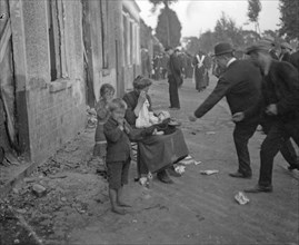 Poor Belgian woman outside her burnt out home in Melle with her two children, is forced to beg for