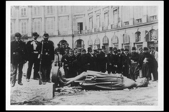 Soldiers beside a knocked down statue of Napoleon I.