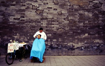 Séance de coiffure au pied des fortifications de la Cité Interdite