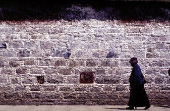 Fidèle marchant le long du Palais de Potala, à Lhassa