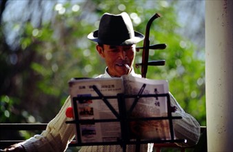A man playing a folk music instrument
