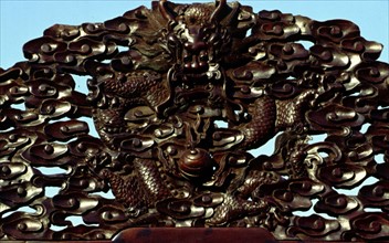 Motif décoratif sur une chaise, représentant des dragons
