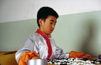 Jeune chinois jouant à un jeu de société