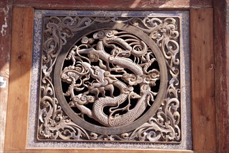 Wood-carved window in dragon design features traditional dwelling of Tianshui. Gansu.